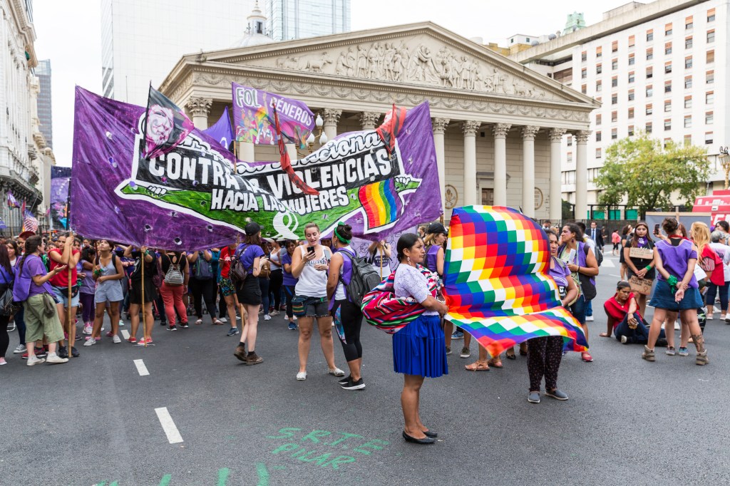 Des manifestantes à Buenos Aires défilant sur le bitume développant une grande banderole violette contre les violences envers les femmes