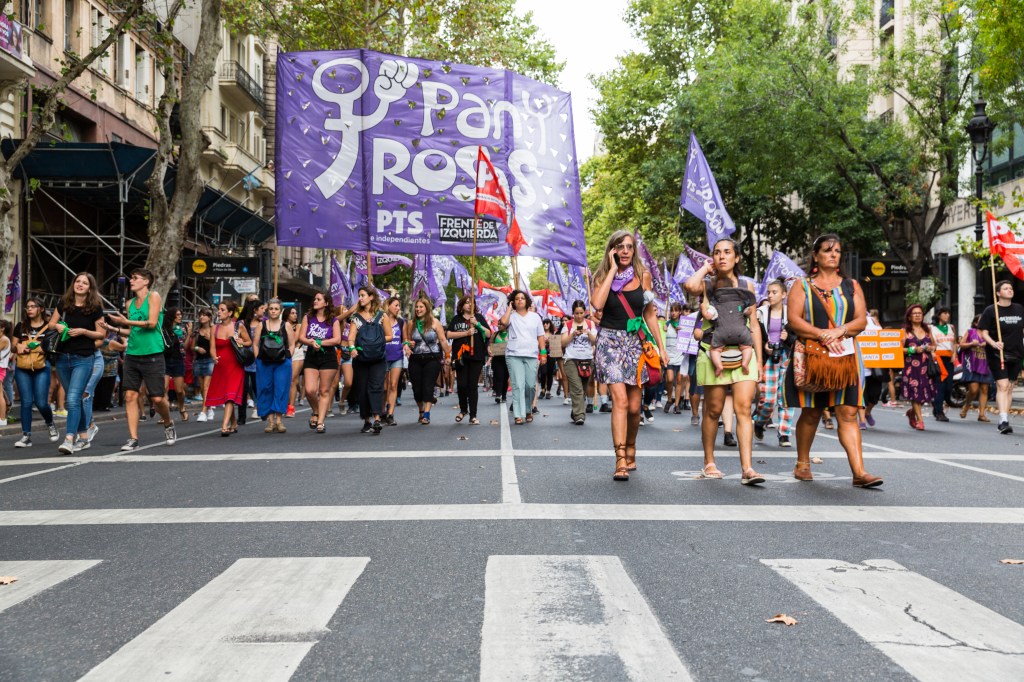 Des militantes marchent dans le cortège et portent de nombreux drapeau violet couleur du féminisme